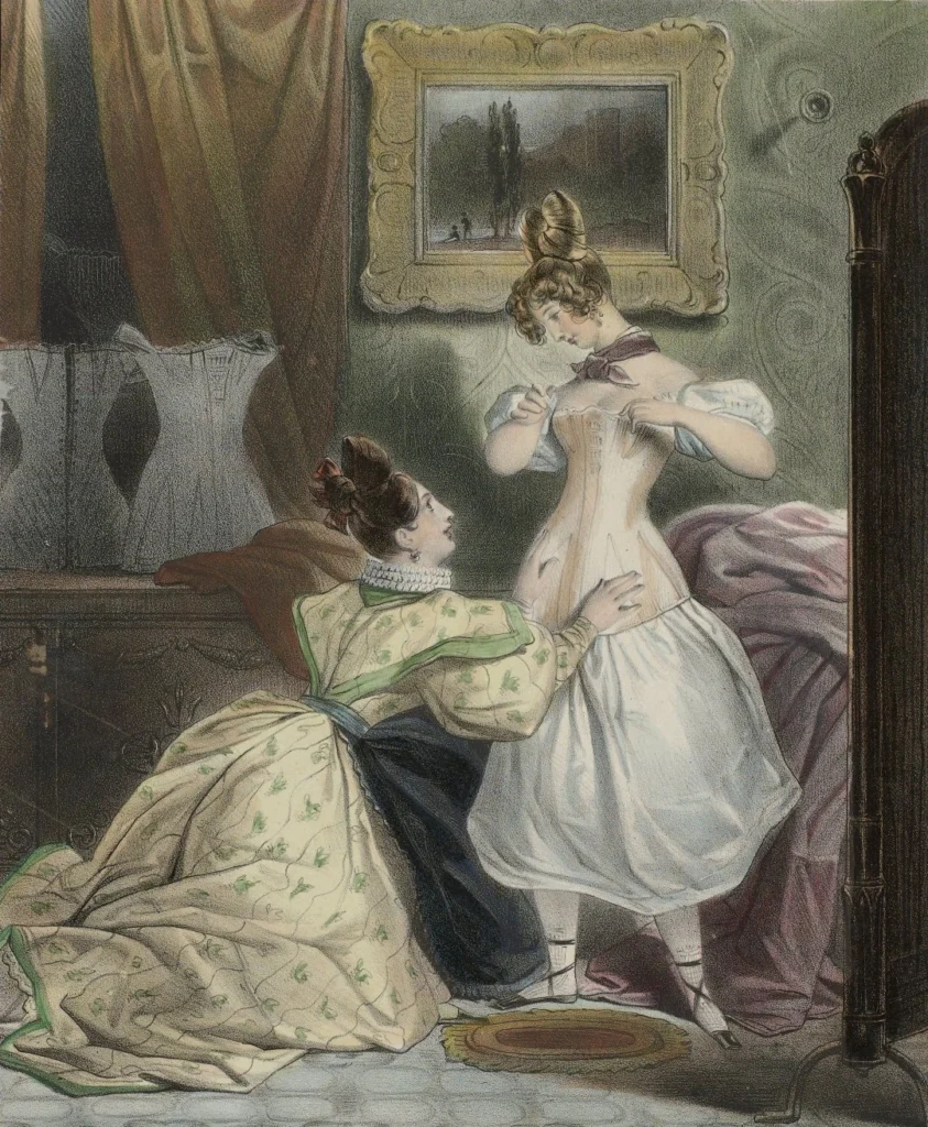 Ilustracja z XIX wieku: dwie kobiety przymierzają gorset w eleganckim pokoju z meblami epoki i obrazem na ścianie.